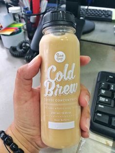 a hand holding a bottle of cold brew coffee