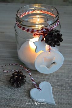 a jar filled with candles and some pine cones