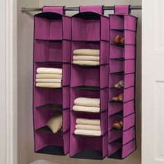 an over the door closet with several purple bins holding folded clothes and other items