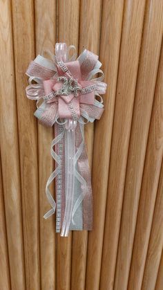 a pink and white ribbon tied to the side of a wooden wall