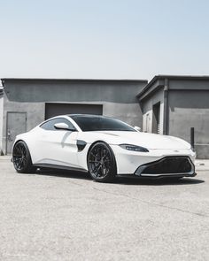 a white sports car parked in front of a building