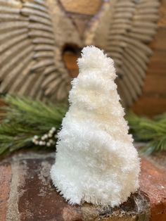 a white stuffed animal sitting on top of a brick wall