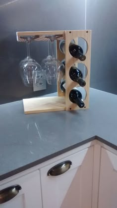 a wooden wine rack with bottles and glasses in it