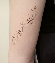 a woman's arm with a star and moon tattoo on the left side of her right arm