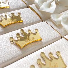 four gold crowns on white napkins with a satin bow in the middle and two for each one