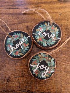 three ornaments with the words love, hope and joy on them hanging from twine