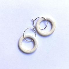 pair of white wooden hoop earrings on white background