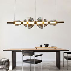 a dining room table with chairs and lights hanging from it's ceiling over it