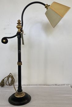 a lamp that is sitting on top of a white sheet covered floor next to a wall