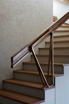 a stair case with wooden handrails and white walls