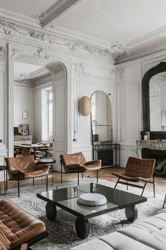 a living room filled with furniture and a fire place next to a mirror on the wall