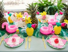 the table is set with pineapples and flamingos