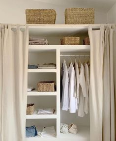 an organized closet with linens, clothes and wicker baskets hanging on the shelves