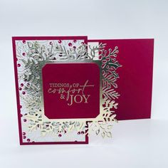 a red and white christmas card with snowflakes on it, saying things of comfort are joy