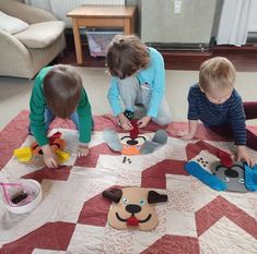 three children playing with paper cutouts on the floor