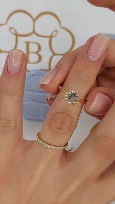 a woman's hand with a ring on it and a diamond in the middle