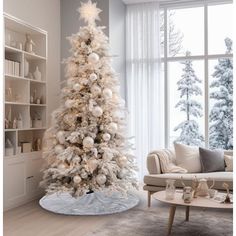 a white christmas tree in a living room next to a window with snow on it