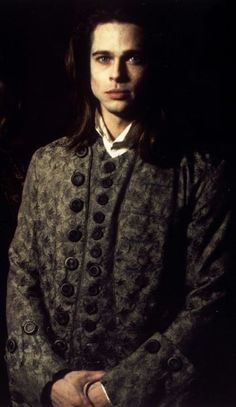 a man with long hair wearing a coat