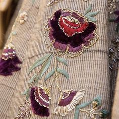 an embroidered jacket with flowers and leaves on it