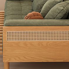 a couch with pillows on top of it in front of a wooden headboard and foot board