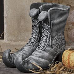 an old pair of boots sitting next to a pumpkin