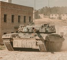 an old tank is parked in front of a brick building