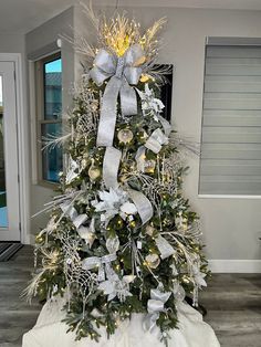 a decorated christmas tree with silver and gold decorations