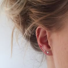 a close up of a woman's ear with two piercings on her ears