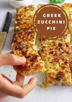 a person is holding up some food on a cutting board with the words greek zucchini pie above it