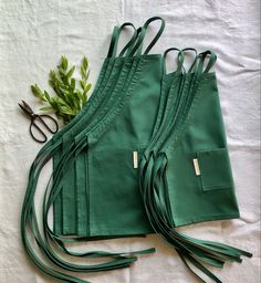 Multiple matching kids aprons in the color teal. Flat lay on white surface. Healing Crystals Decor, Banda Bags, Alpaca Wool Blanket, Matcha Tea Powder, Childrens Aprons, Black Honey, Ethical Shopping, Natural Textiles, Kids Apron