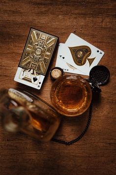 some cards and a glass on a wooden table with a teapot in the middle