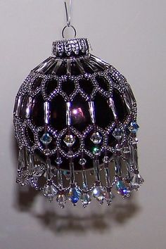 a black and white ornament hanging from a hook with crystal beads on it