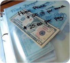 a stack of twenty dollar bills sitting on top of a binder next to a keyboard