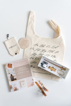 the contents of a tote bag are laid out on a white surface with other items