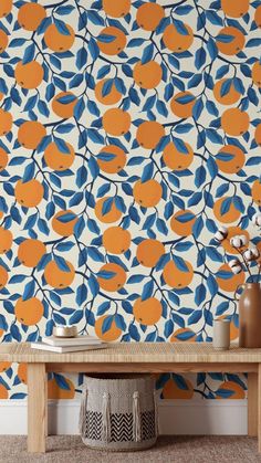 an orange and blue wallpaper with leaves on it, next to a wooden table