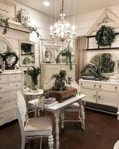 a room filled with white furniture and lots of greenery on top of the walls