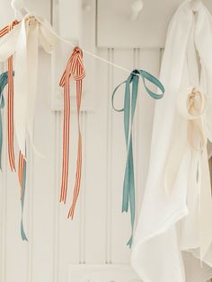 three ribbons hanging from clothes line in front of white wall