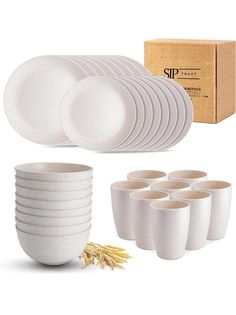 a set of white plates and cups in front of a cardboard box