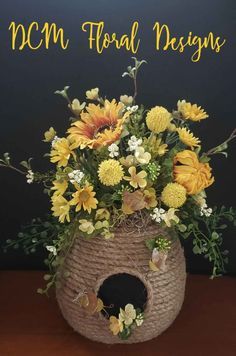 a flower arrangement in a woven basket with the words mcm floral designs above it