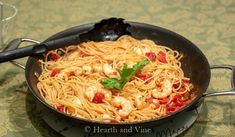 a pan filled with pasta and shrimp on top of a table