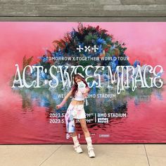 a woman standing in front of a large poster