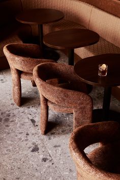 some chairs and tables in a room with tile flooring on one side and the other end