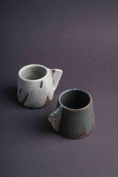 two ceramic cups sitting on top of a table