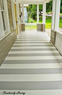 a porch with white and gray stripes on the floor