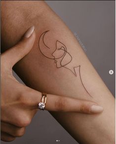 a woman's arm with a tattoo on it that has two faces and a crescent