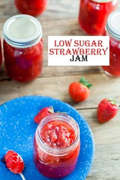 a blue plate topped with strawberry jam next to jars