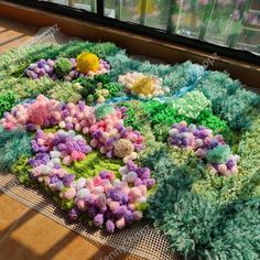 a pile of fake flowers sitting on top of a floor next to a window sill