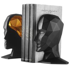 two bookends made to look like faces with books in the shape of heads