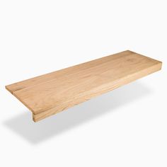 a wooden shelf sitting on top of a white wall in front of a white background