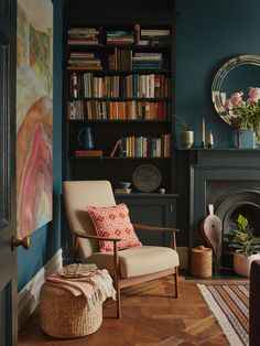 a living room with bookshelves and a chair in front of a fire place